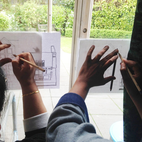 Using the window as a light box to trace our designs onto cloth.